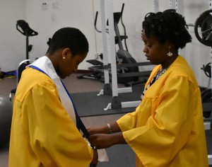 Marquitta Taylor (right) adjusts the sash of Jessica Bates (left) prior to commencement ceremonies.