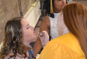 Taylor Richardson gets a final touch-up on her lips with the assistance of Baylee Crew.