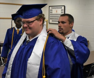 Mark Bostick (right) makes sure that the collar of salutatorian Matthew Bartle (left) is straight after straightening up his honor cords.