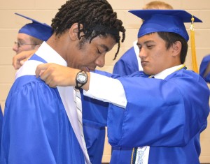 James Giffin (right) helps Chris Campbell (left) put the finishing touches on his graduation attire.