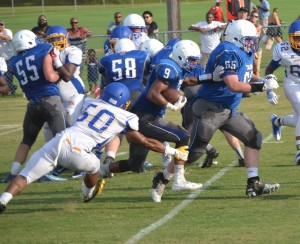 New Kent’s Lamont Brandon (9) receives a key block from John Holland (65) as he eludes Charles City’s Andre’ Mason (50).