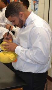 Trevon Adkins signs his name on the "senior duck" to signify the unity of the class of 2014.