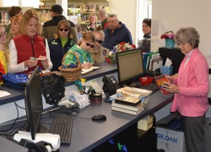 Despite the grand opening, usual business continues for the library as books and other items are checked out at the front desk.