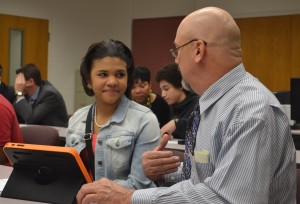 District 2 supervisor Bill Coada (right) asks a question to student guide Keonna Motley to solve a problem using the tablet. 