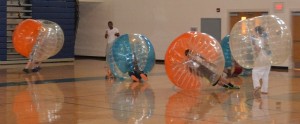 Kids and adults take tumbles in a game of bubble soccer, one of the fair’s newest activities, inside the high school gymnasium.