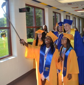 Aliyah Tabb holds a selfie stick to capture memories with classmates prior to commencement.