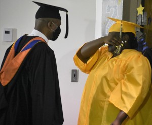 Teanna Jackson is in tears on her special day as senior sponsor John Christian (left) offers words of encouragement before her march in to receive her diploma.