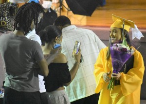 A bouquet of flowers and a bright smile compliments outgoing graduate Nijah Johnson after she is greeted by family and friends.
