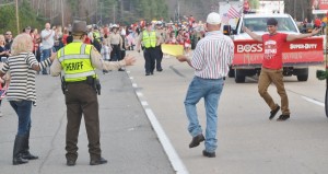 Levi Scott (right) emerges from the back of Providence Forge Hardware’s float to shock parents Larkin and Dale (left) after working overseas in Germany.
