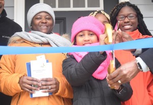 Little ones of Rotonya Mason's family receive the honors to christen the new home with the ribbon cutting.