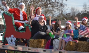 Kids wave with Santa and Mrs. Claus, who rode on the back of Dennis Trucking as a runner-up in the parade.