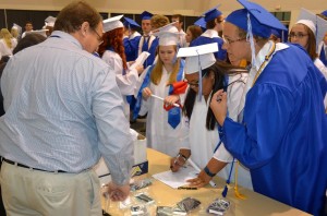 After the ceremony, Amber Holmes (center) is all too happy to sign for her high school diploma.