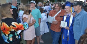 Justin RaBorg is more than happy to show off his diploma in a family photo outside the Siegel Center.