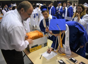 After the ceremony, Ben Hager inks his name on the sign-out form to receive his diploma.