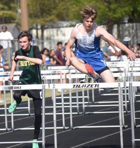 New Kent’s Logan Frederick (right) clears a hurdle just before Bruton’s Sam Mann (left) on his way to winning heat one of the boys’ 110-meter hurdles.