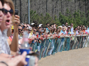 Spectators line the rail, cheering for their favorite mount.