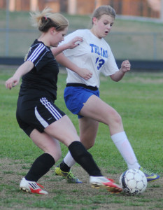New Kent's Kristen Taylor (13) battles for control of the ball with King William's Hannah Rhea.
