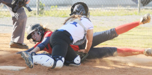 New Kent catcher Stephanie Torrence blocks the plate and tags out Grafton's sliding Hannah Olson at the plate in the fifth inning.