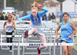 Lady Trojan Savannah Grant clears the final barrier in Saturday's 100 meter hurdle event.