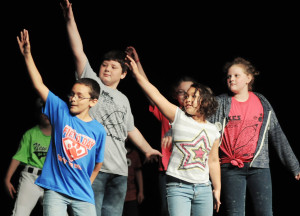New Kent Elementary students show off their "folk dance" moves before a crowd in the auditorium.