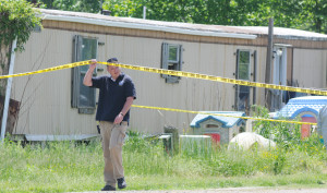 New Kent Detective Joey McLaughlin slips under police tape in front of the trailer where this afternoon authorities took down a methamphetamine/marijuana operation.Alan Chamberlain photos