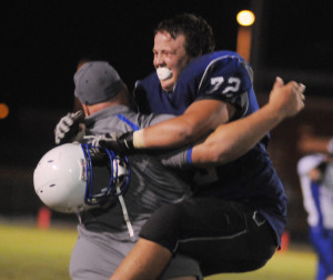New Kent tackle Wilson Gregory leaps into the arms of head coach Dan Rounds as the Trojans celebrate the end of a 12-game losing streak.