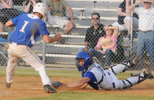 Trojan Clay Simpson sidesteps the diving tag attempt by Hopewell catcher Travis Hogan to score New Kent's final run on a wild pitch.