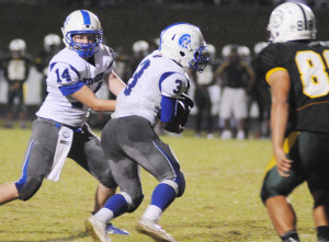 New Kent running back Davion Barnes takes a handoff from quarterback Mike Burt on the way to some of his 287 yards.