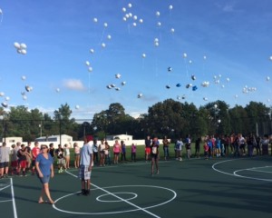 Family and friends release balloons into the air during a Tuesday vigil honoring the student-athlete.