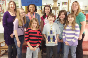 New Kent Elementary School’s It’s How You Look At It Team of (front, l to r) Campbell Gowdy, Indy Bennett, Emma West (back, l to r) coach Holly Perez, Sarah Cook, Isis Cutler, Megan Smith, Tylar Strickland, and coach Laura Beach display their first place trophy.